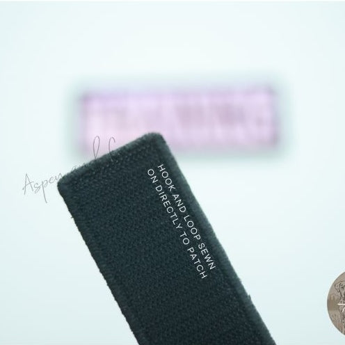 Close-up of the hook side backing on the reverse of a holographic embroidered dog patch, designed for easy attachment to collars, harnesses, vests, or capes with loop fasteners.