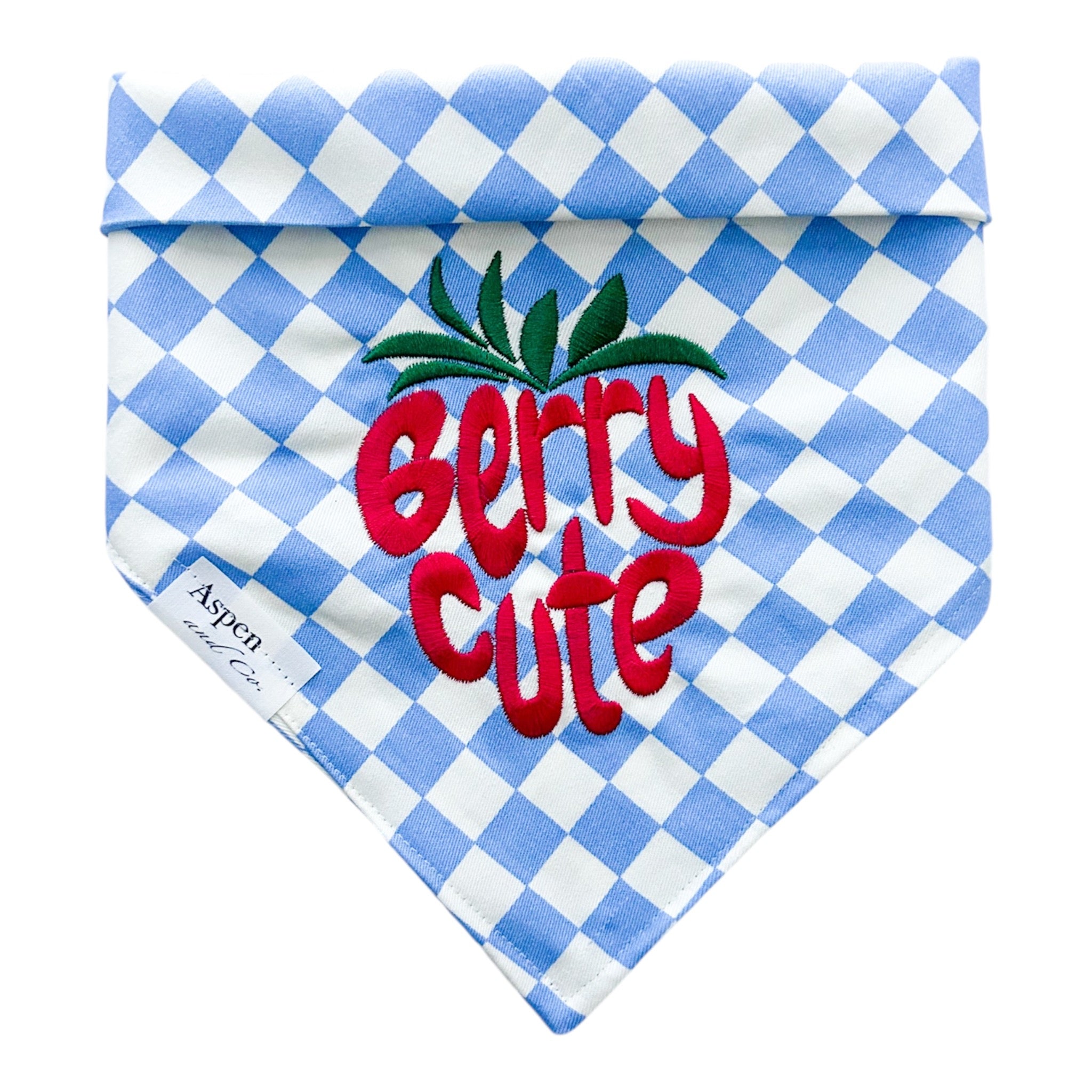 Blue and white gingham embroidered dog bandana with red strawberry design and “berry cute” text, reversible with snap closures for collars, harnesses, or vests.