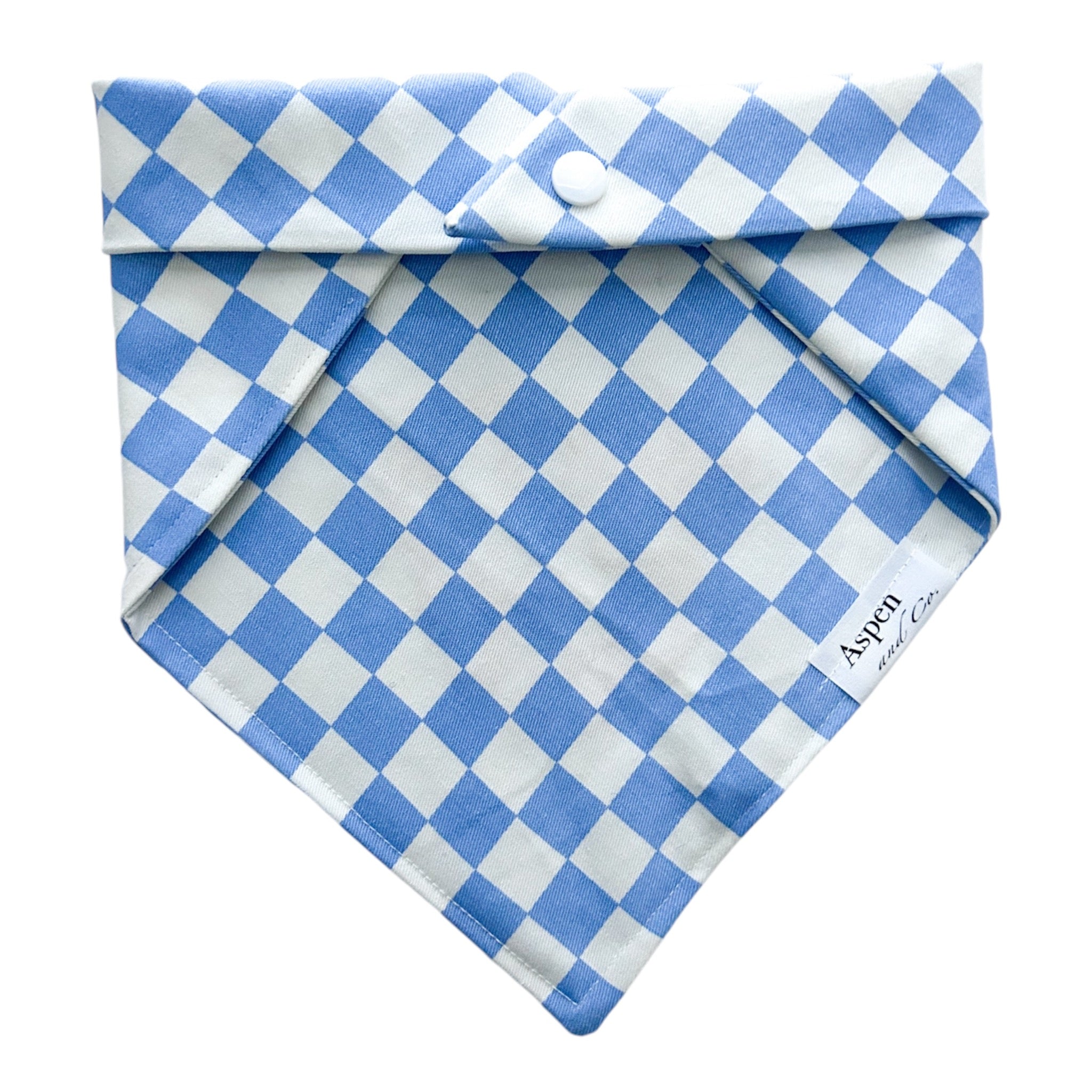 Back of blue and white gingham dog bandana showing plain side with snap closures for easy attachment.