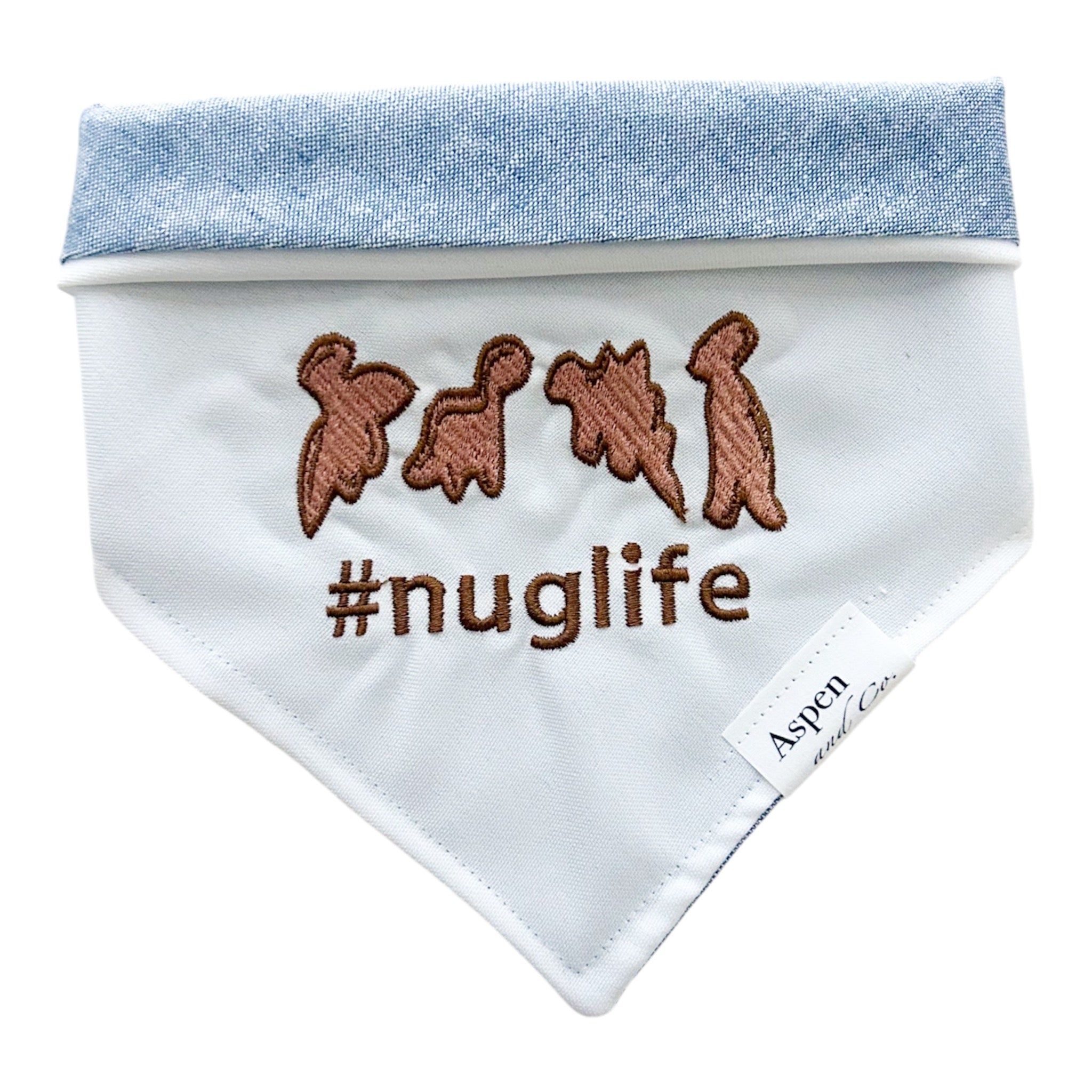 Dog bandana with embroidered "#nuglife" text and Dino-shaped nugget design on white linen front.