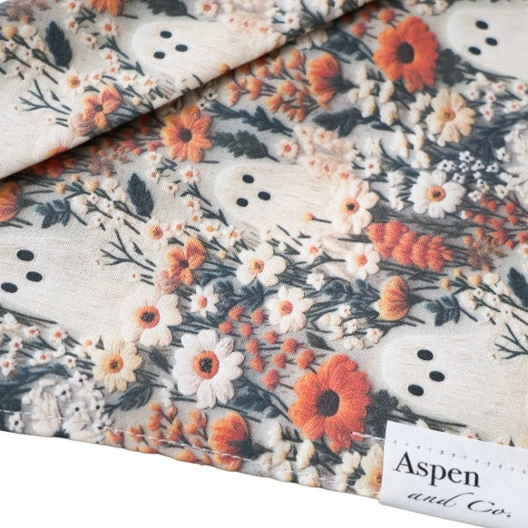 Close-up of Ghostie dog bandana in autumn colors with small ghosts, foliage, and florals, without ruffled trim
