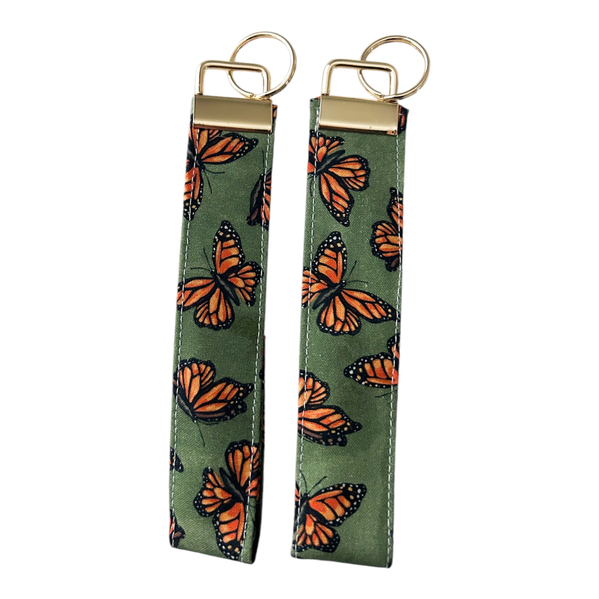 Olive key fob wristlet featuring assorted monarch butterfly print with gold  hardware.