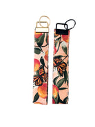 Peach key fob wristlets with monarch butterfly print showing both gold and black hardware options, durable cotton fabric, perfect for keys.