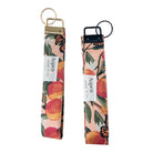 Back view of peach monarch butterfly key fob wristlets showing Aspen and Co tag with gold and black hardware options, durable cotton fabric, perfect for keys and IDs