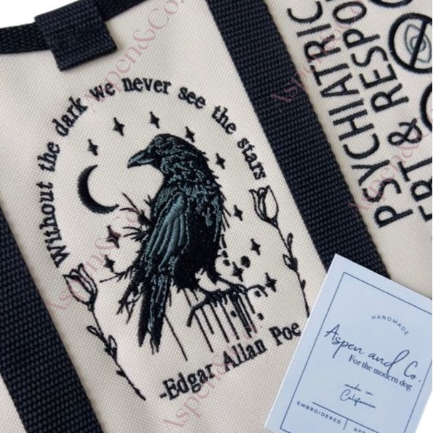 Close-up of embroidered raven and quote panel