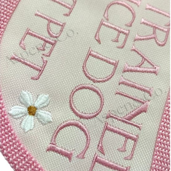 close up of pink service dog vest showing embroidered floral accents.