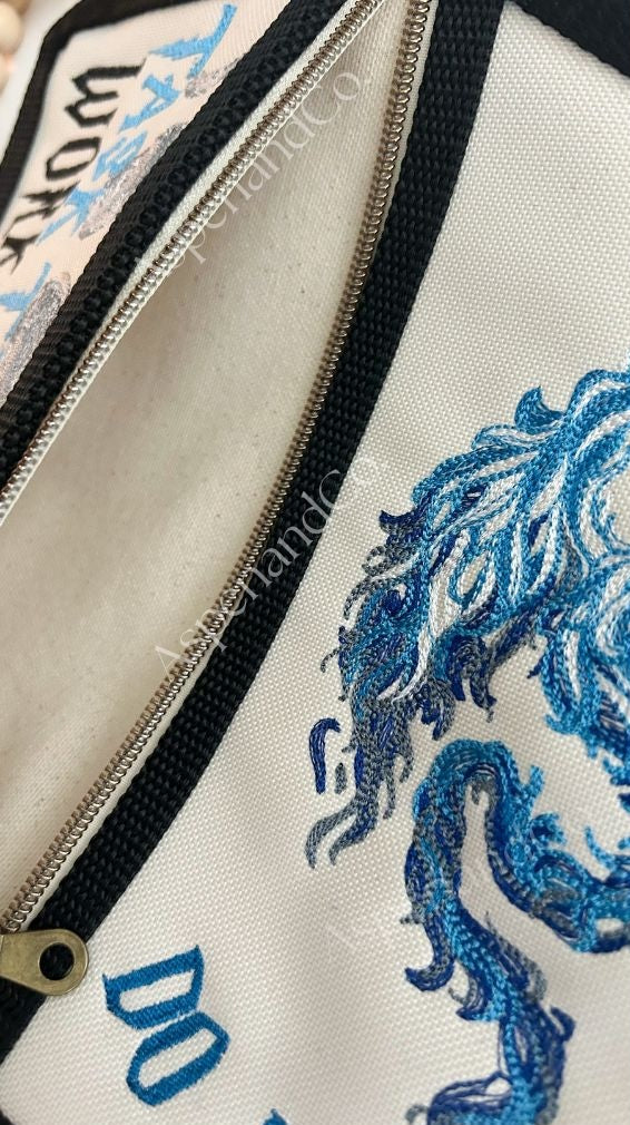 Close-up of a service dog vest pocket with blue dragon design.