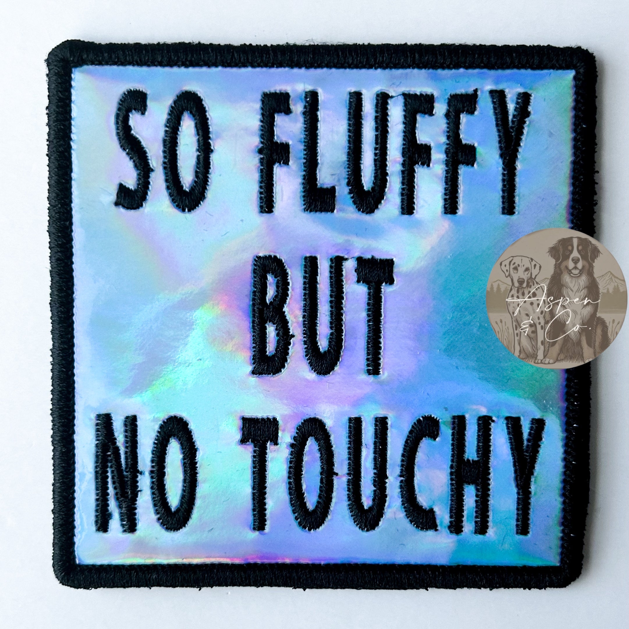 Blue holographic embroidered dog patch with black 'So Fluffy But No Touchy' text, designed to attach to dog vests, harnesses, or capes.