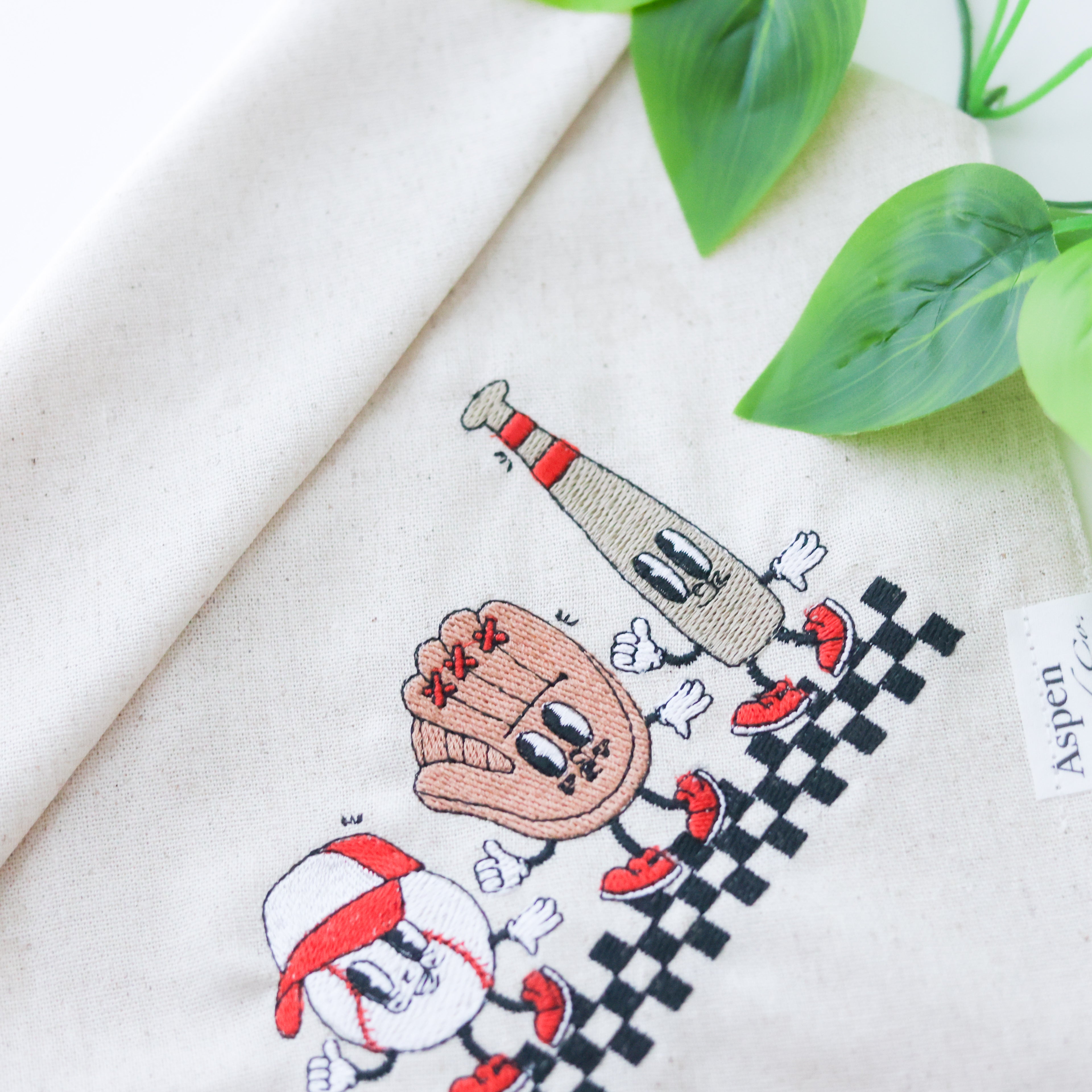 Linen dog bandana with embroidered smiley baseball, glove, and bat wearing a cap – sporty design perfect for baseball-loving pups.