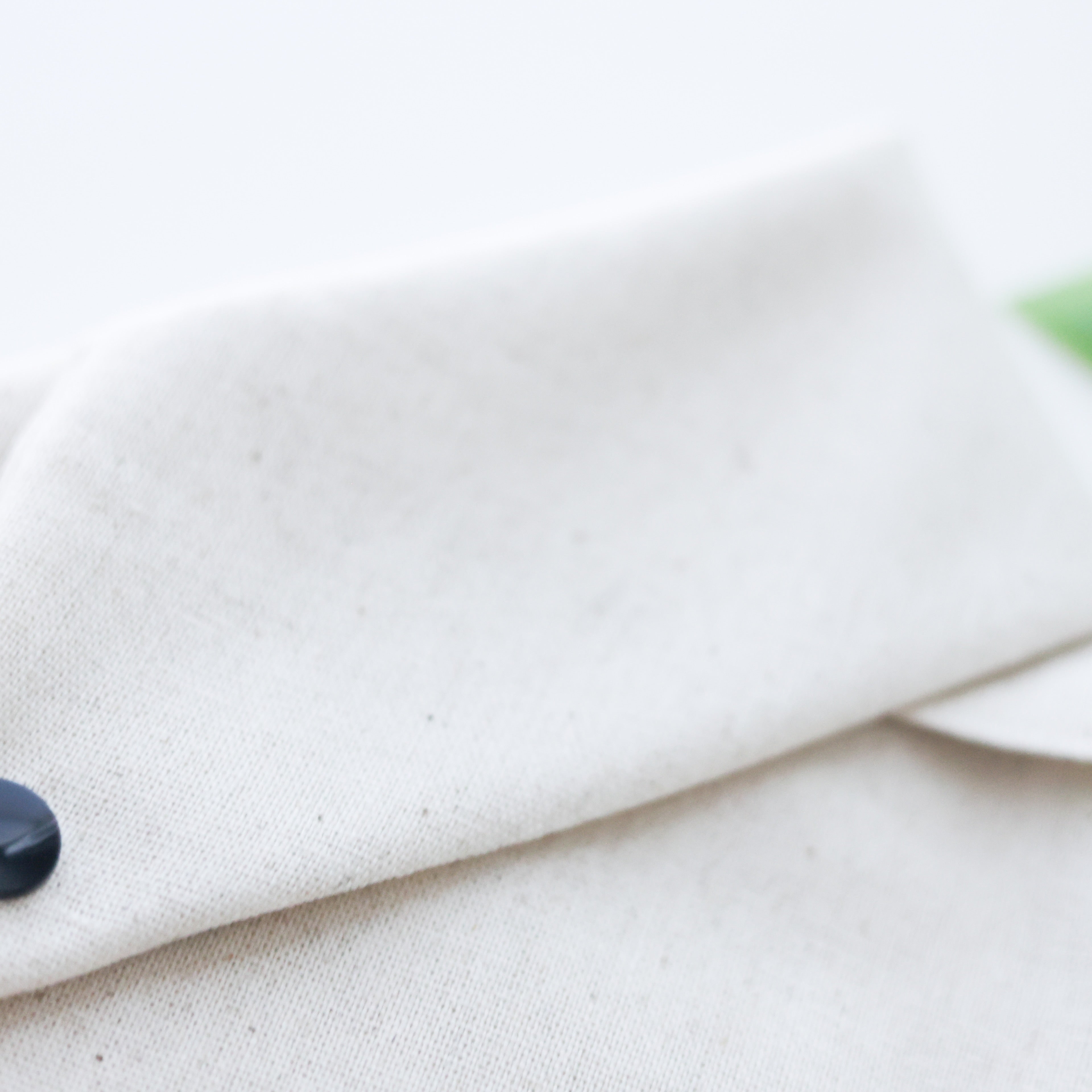 Back view of linen dog bandana featuring plain fabric with secure, adjustable snap closures for easy wear.