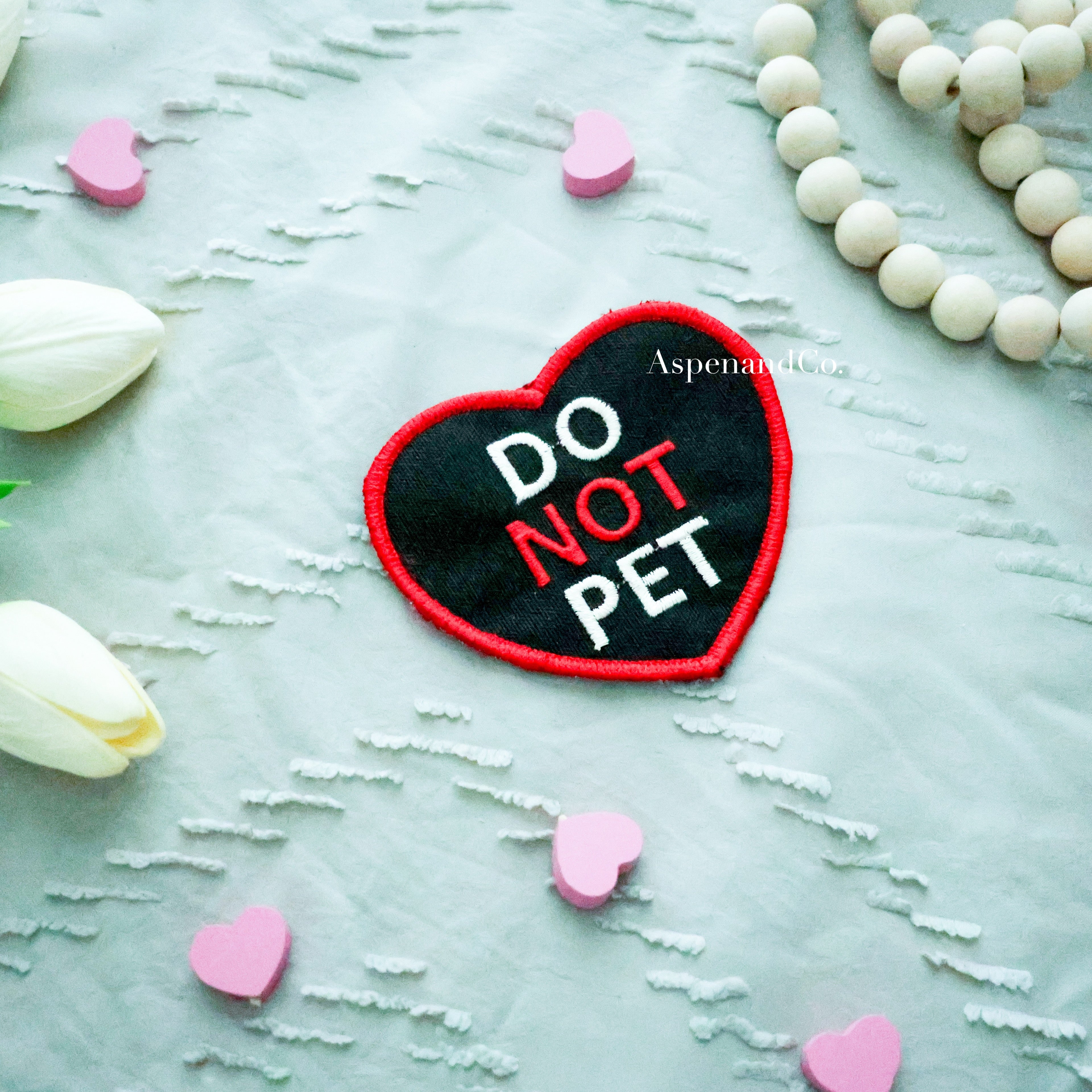 Black embroidered heart-shaped patch with 'DO PET' in white and 'NOT' in red, water-resistant with hook backing