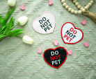 Three embroidered heart patches in pink, white, and black, each reading 'DO NOT PET' with color-coordinated stitching