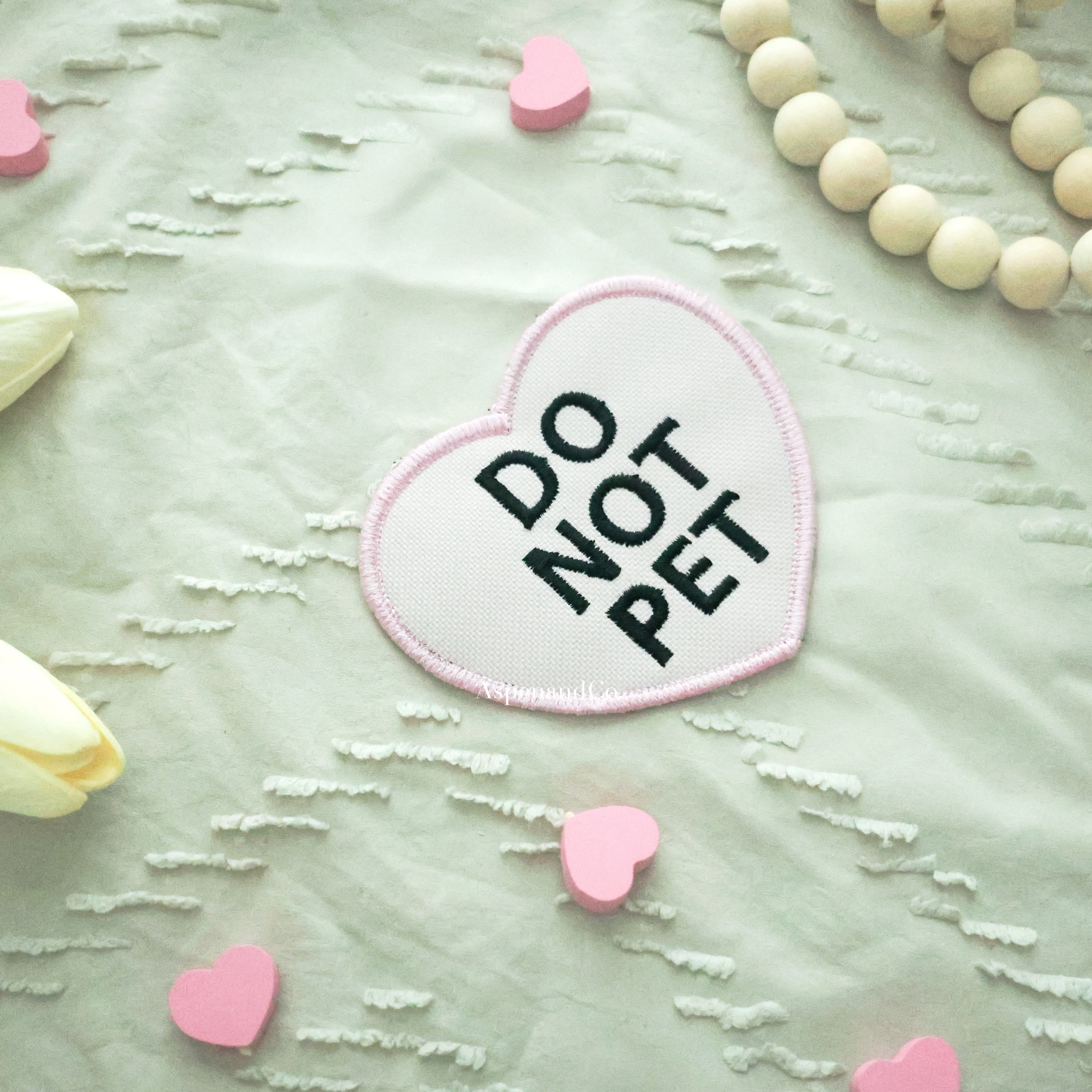 Pink heart patch with bold black 'DO NOT PET' lettering and matching embroidered edge, water-resistant design