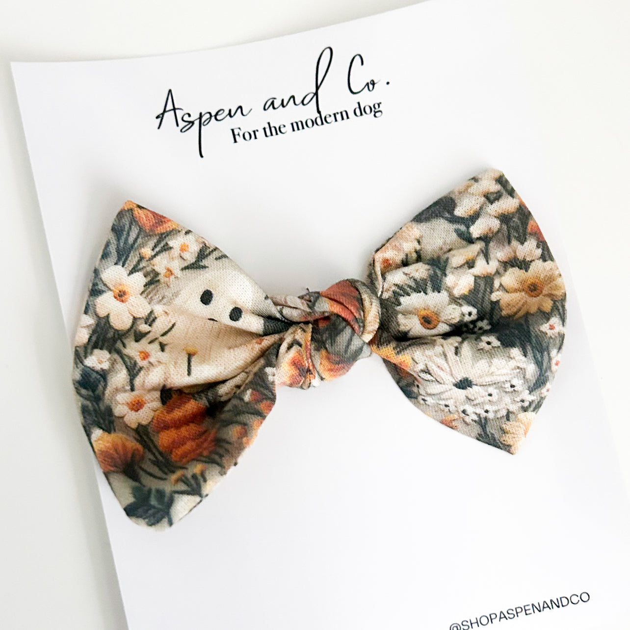 Ghostie bow with autumn-themed design featuring small ghosts, foliage, and florals, perfect for humans or dogs as a festive accessory.