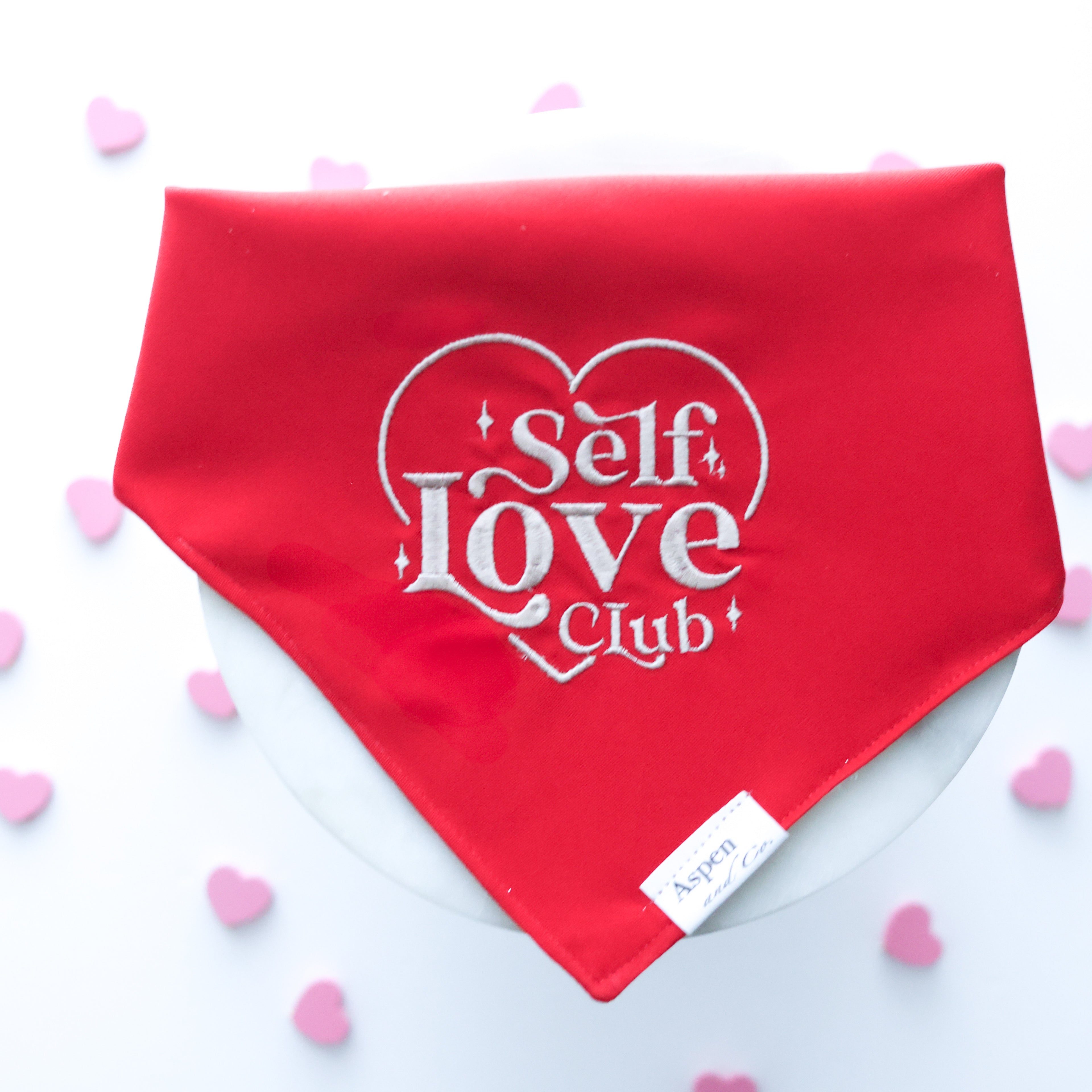 SEO-optimized image alt text:
Cool-toned red dog bandana with beige embroidery reading “Self Love Club” inside a heart shape; perfect for mental health awareness and everyday wear.