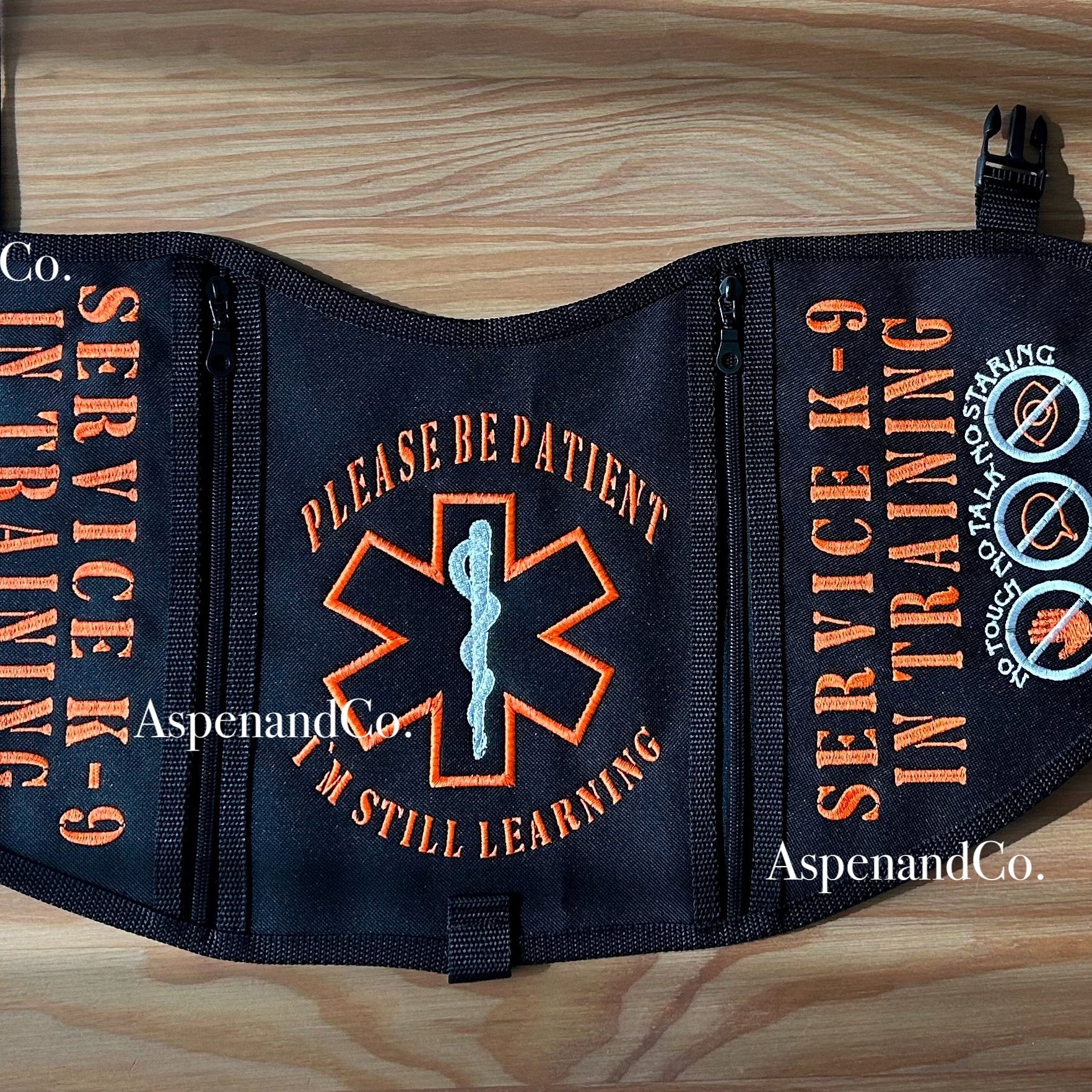 Service K-9 in Training vest on a wooden surface with decorative elements.