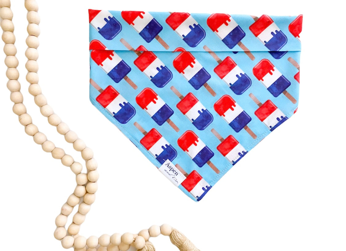 Blue dog bandana with red, white, and blue popsicle print.