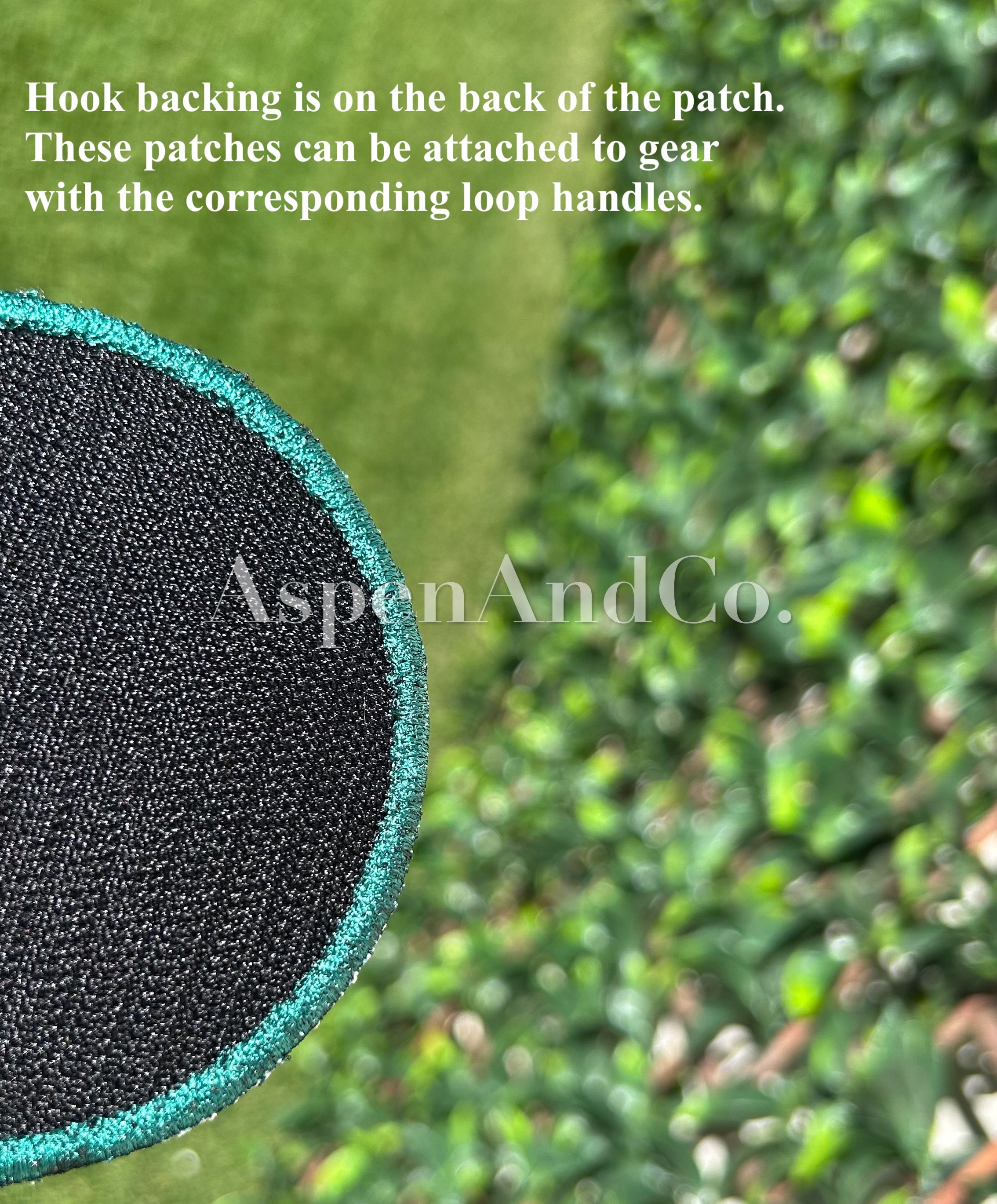 Close-up of a black patch with green border on a green background, featuring text about hook backing and AspenAndCo branding.
