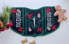 Black and green Christmas-themed service dog vest with cookie embroidery, medical alert symbol, and holiday text. Features two zippered pockets