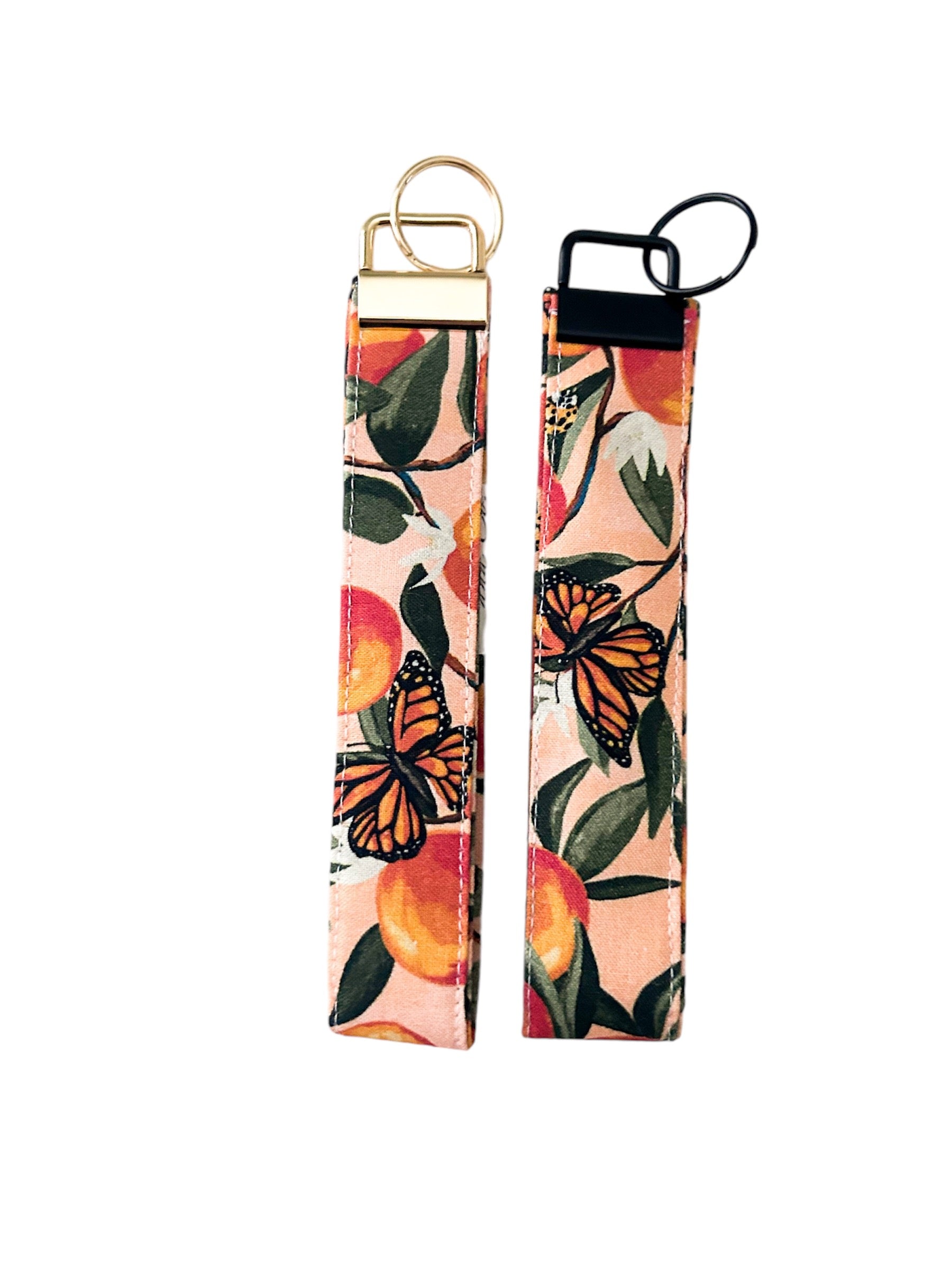 Peach key fob wristlets with monarch butterfly print showing both gold and black hardware options, durable cotton fabric, perfect for keys.