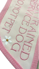 close up of pink service dog vest showing embroidered floral accents. 