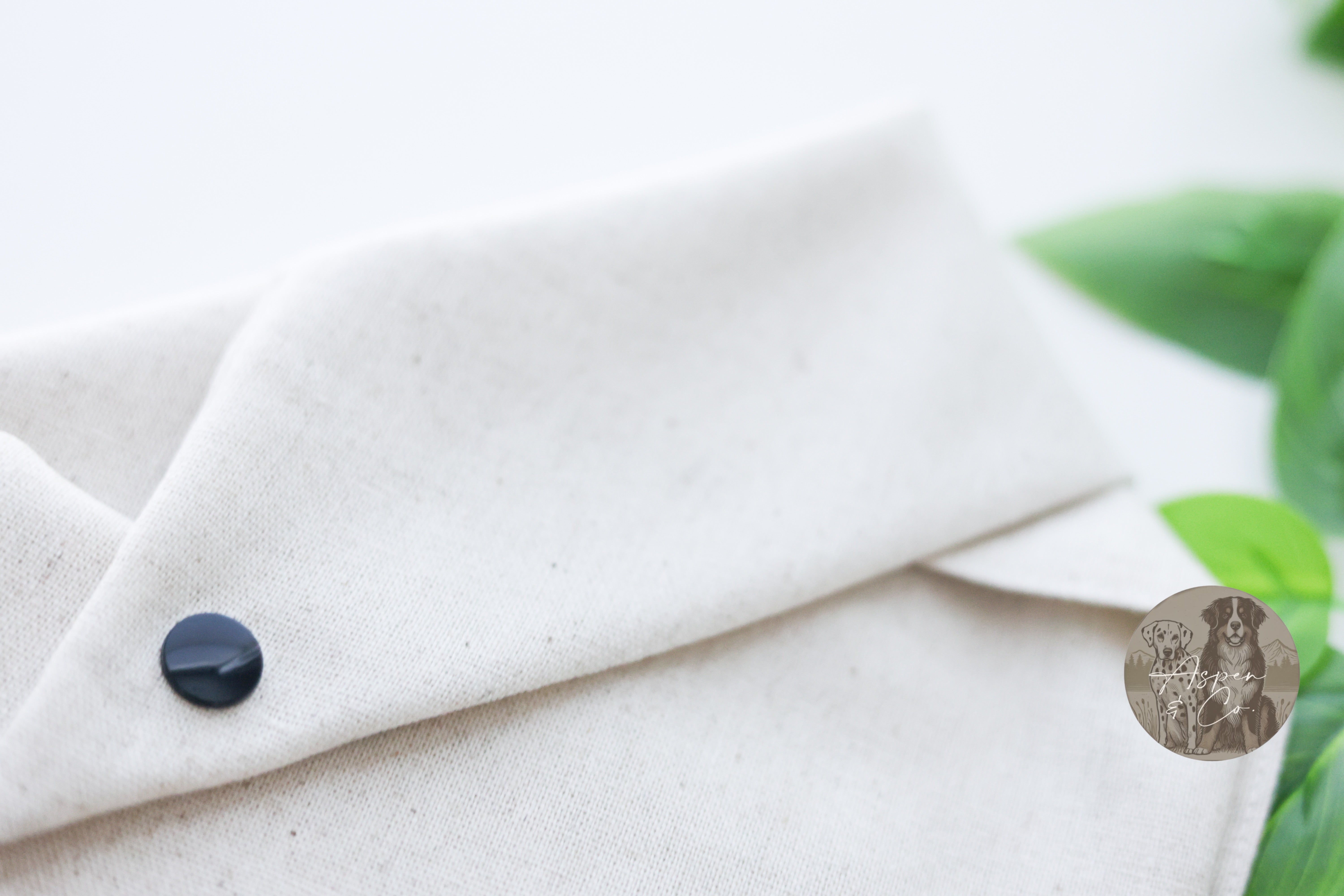 Back view of linen dog bandana featuring plain fabric with secure, adjustable snap closures for easy wear.