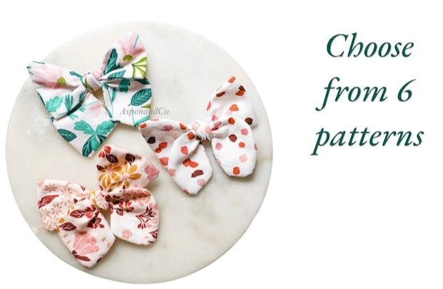 Hand-tied dog bows in 6 assorted patterns can be selected and worn on an alligator clip or soft nylon headband. Handmade by Aspen and Co. in Southern California.
