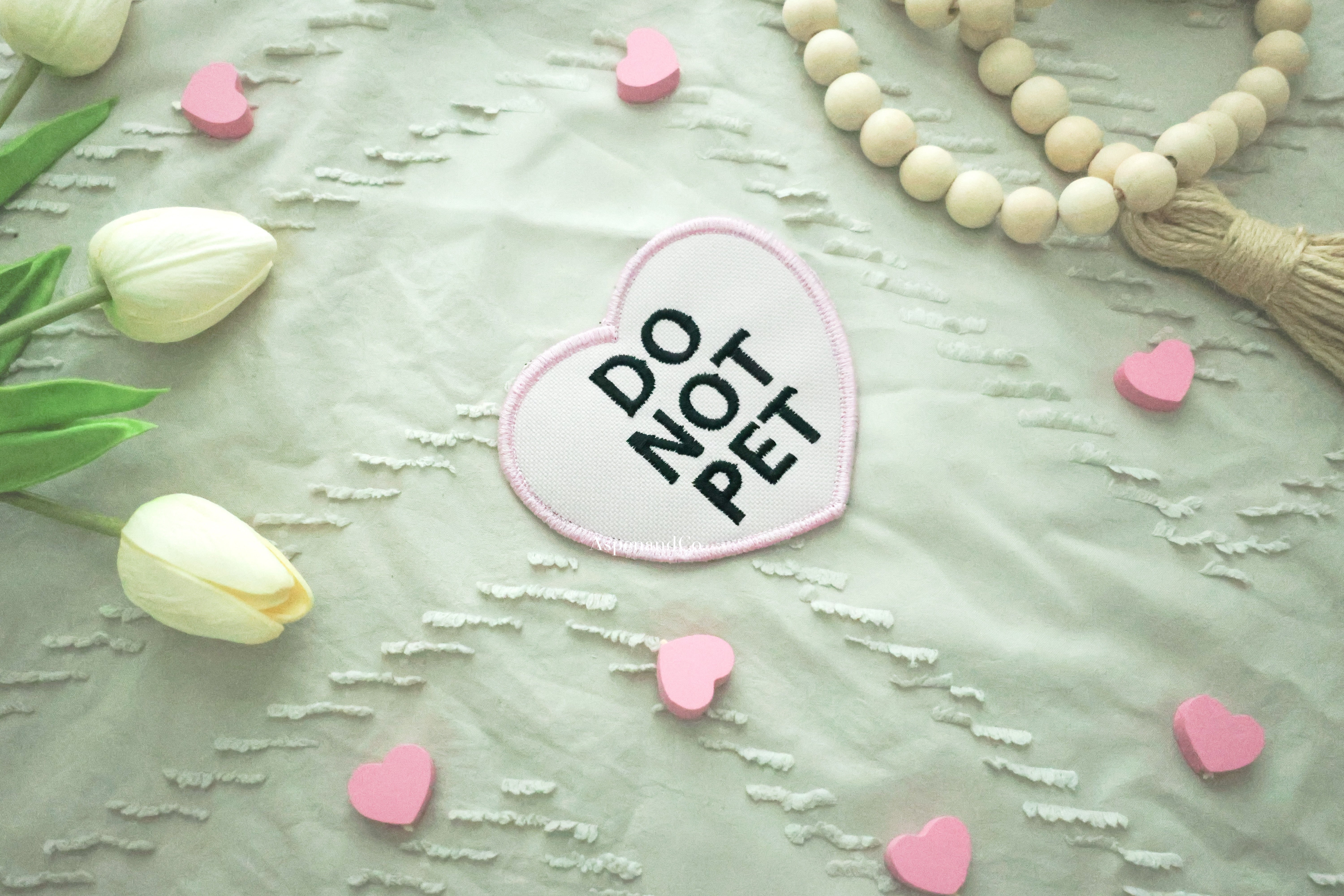 Pink heart patch with bold black 'DO NOT PET' lettering and matching embroidered edge, water-resistant design