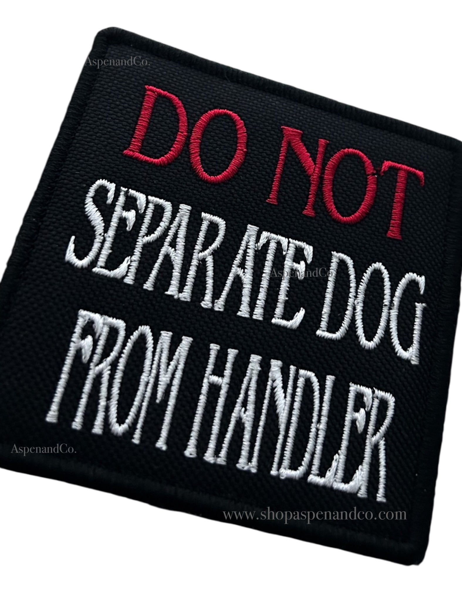 Black patch with red and white text 'DO NOT SEPARATE DOG FROM HANDLER' on a white background