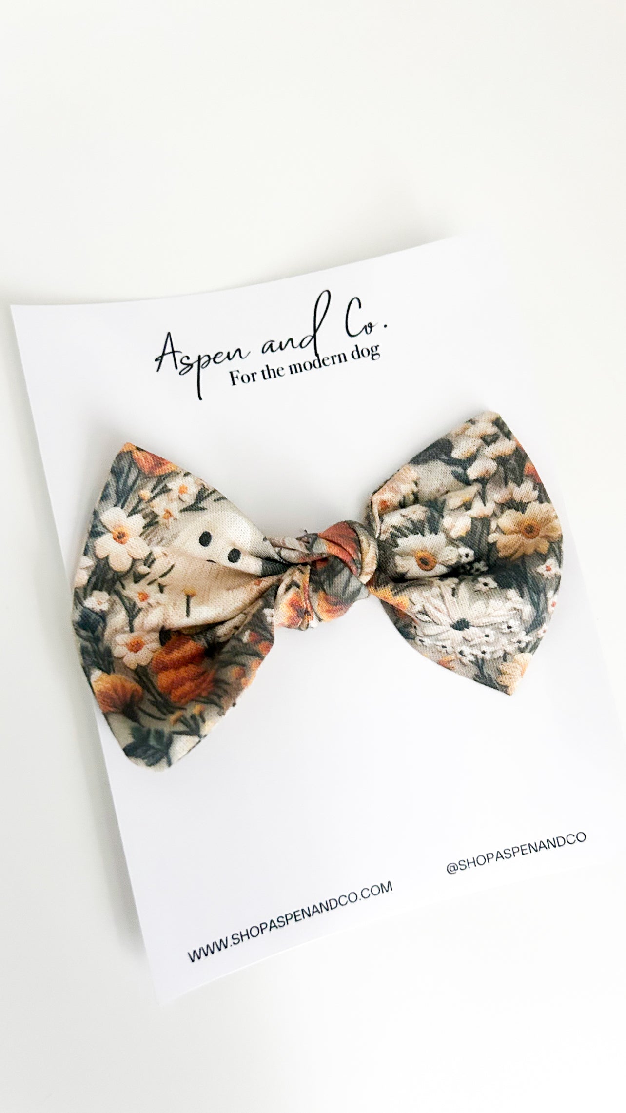 Ghostie bow with autumn-themed design featuring small ghosts, foliage, and florals, perfect for humans or dogs as a festive accessory.