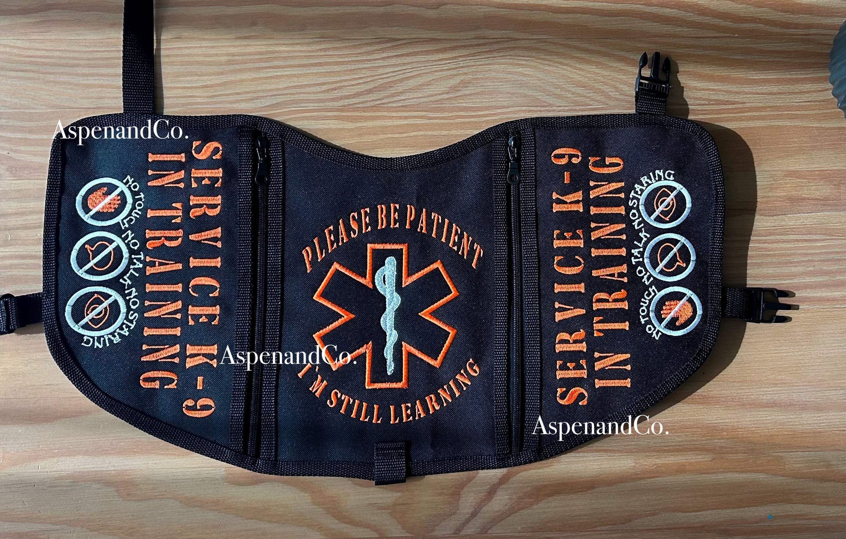 Service K-9 in Training vest on a wooden surface with decorative elements.